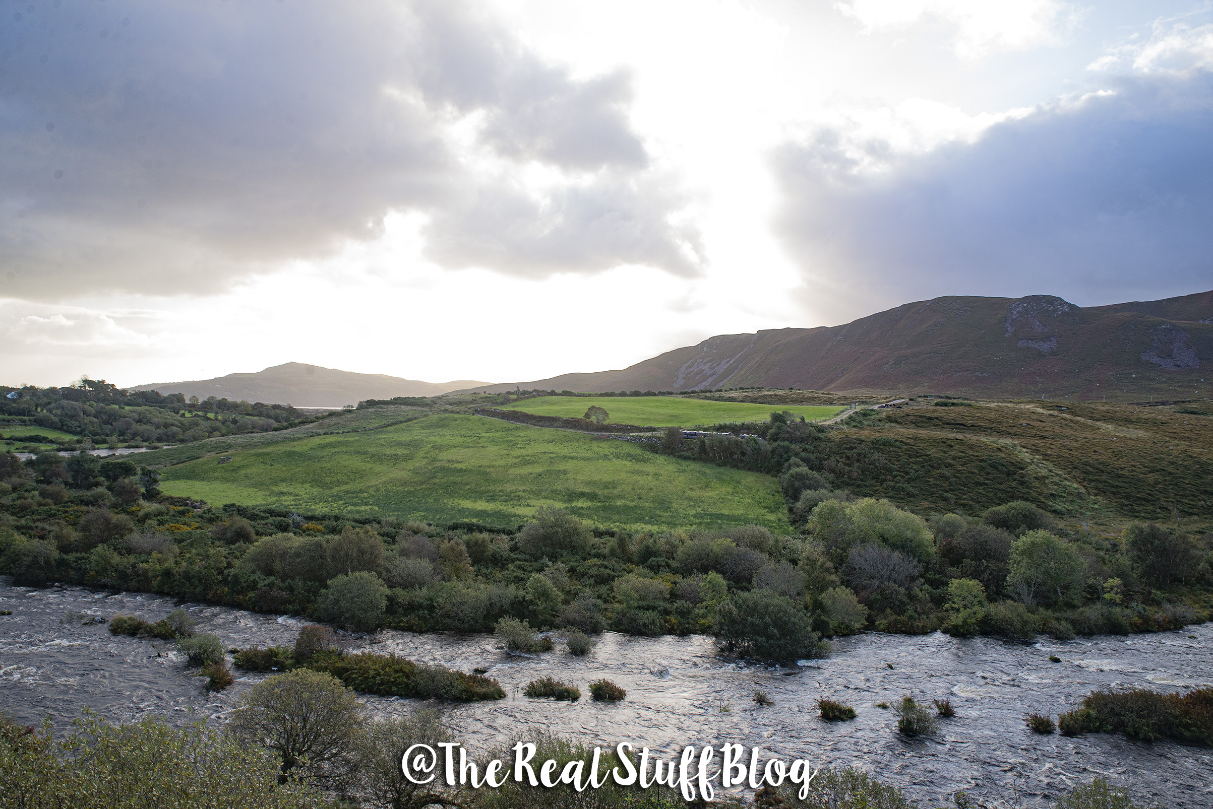 Mountains over farmside with a stream in Ireland